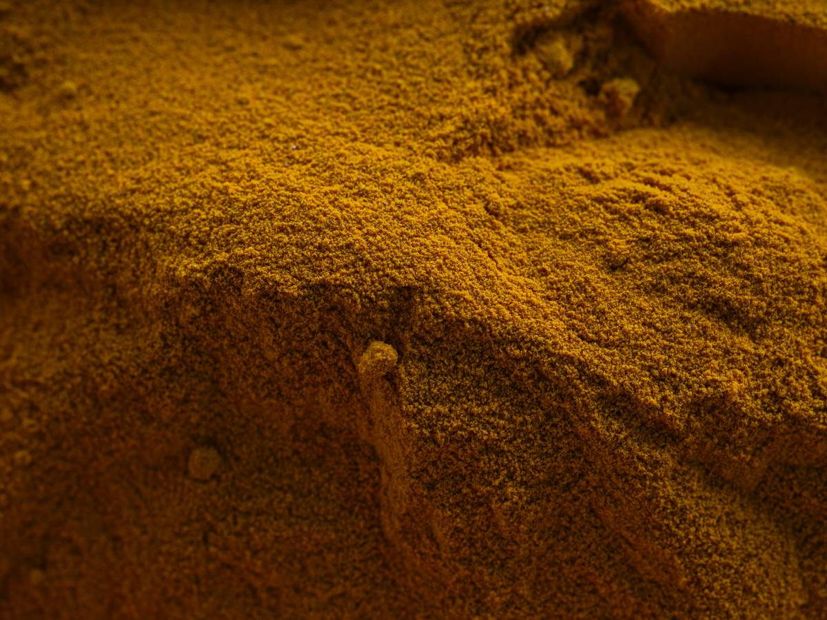 Golden retriever scratching ear next to turmeric supplement bottle labeled turmeric allergy care aid